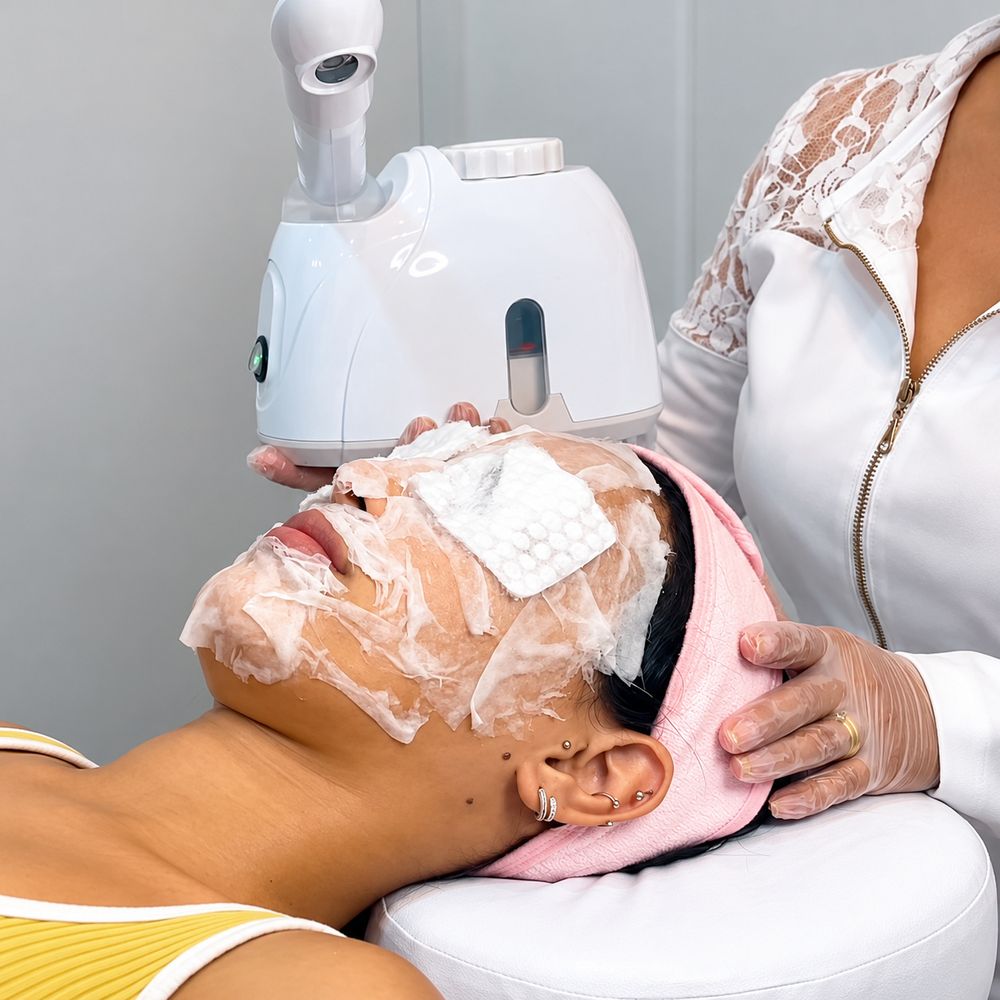 Profissional de jaleco branco durante uma limpeza de pele com vapor